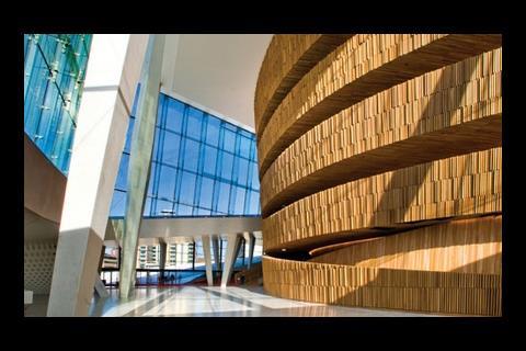 The curved back of the main auditorium is richly textured by myriad slats of natural oak.
